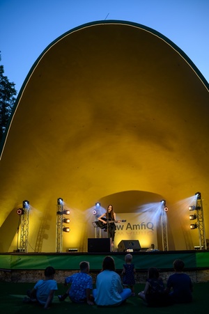 Koncert: "Ballady na głos i gitarę" - Łucja Kania - Na scenie śpiewająca i grająca na gitarze Łucja Kania
