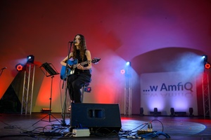 Koncert: "Ballady na głos i gitarę" - Łucja Kania - Na scenie śpiewająca i grająca na gitarze Łucja Kania